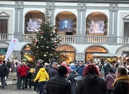 Menschenmenge auf dem Adventmarkt vor Schloss Kobersdorf, geschmückter Weihnachtsbaum und beleuchtete Verkaufsstände im Hof.